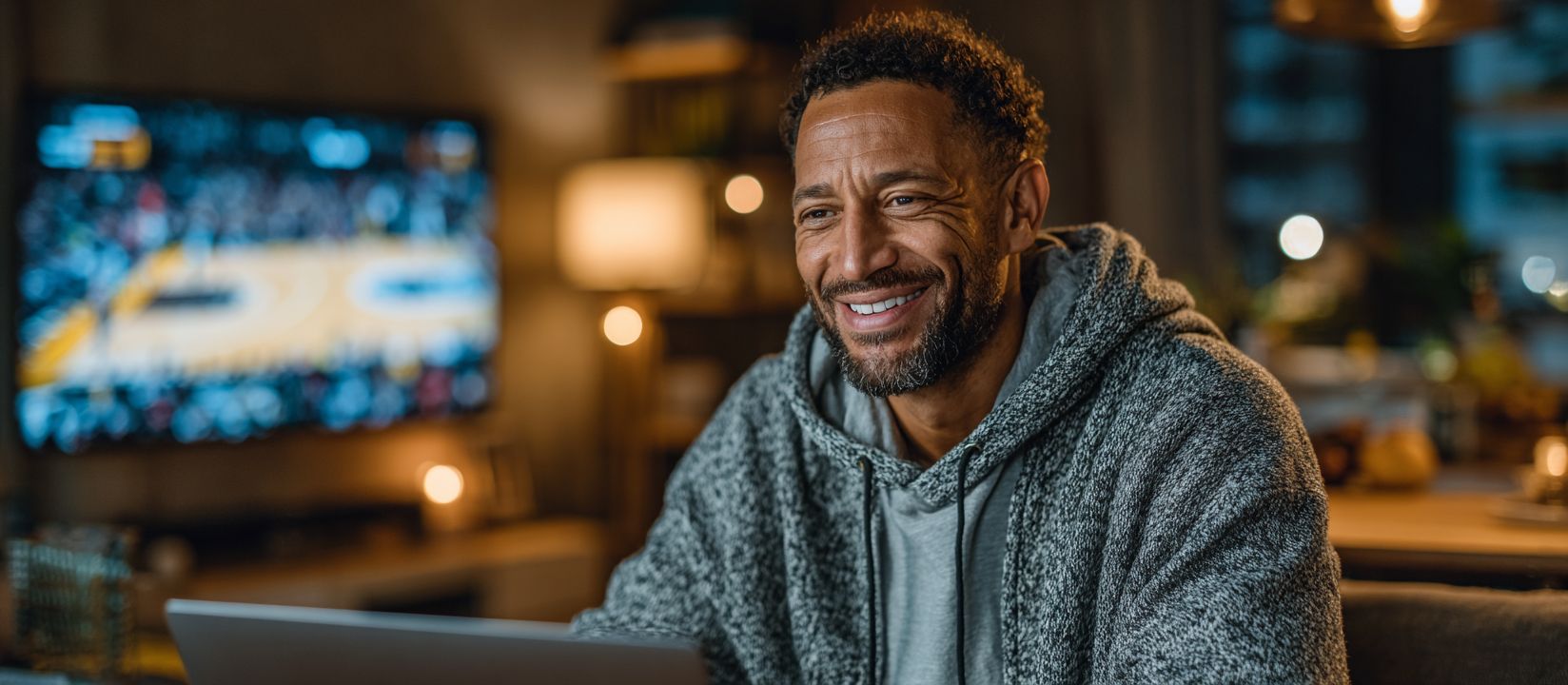 Happy man betting online on sports at CV333 Casino while watching a live basketball game